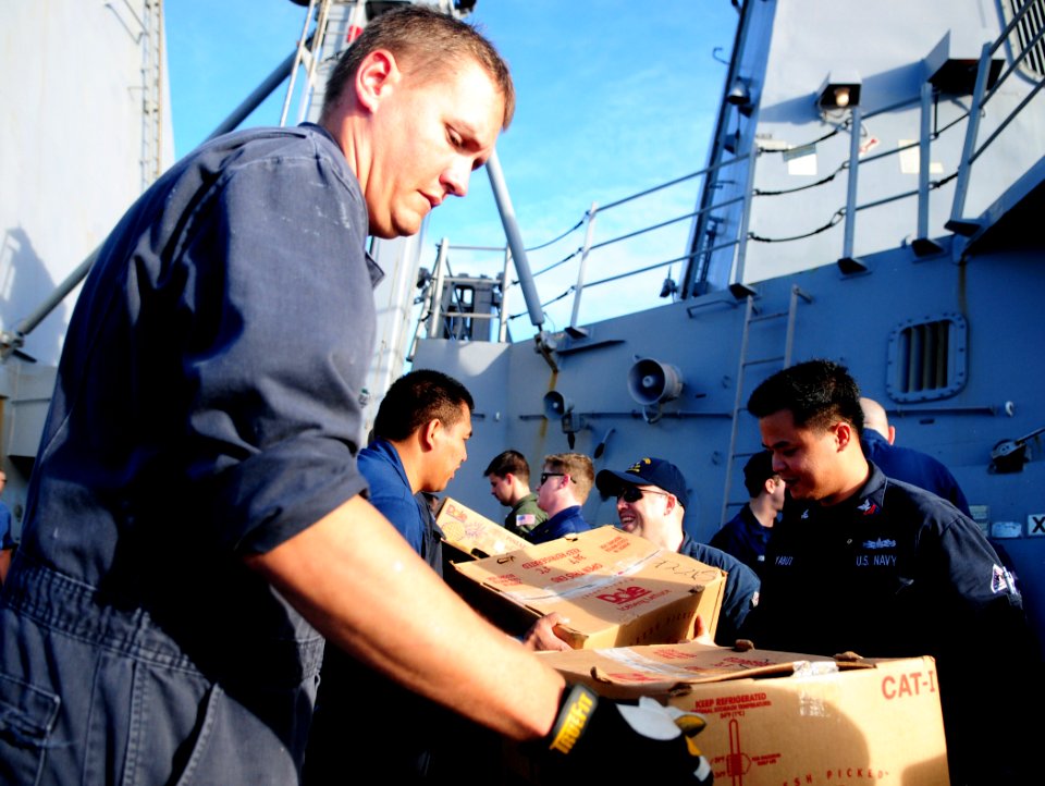 US Navy 111221-N-ZF681-456 Sailors aboard the guided-missile destroyer USS Halsey (DDG 97) unload supplies during a replenishment at sea with the M