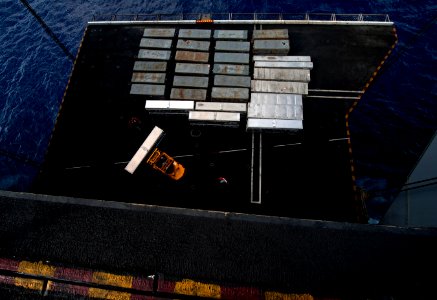 US Navy 111222-N-DR144-146 Aviation Ordnancemen assigned to Weapons Department's G-1 Division move crates of ordnance from an aircraft elevator