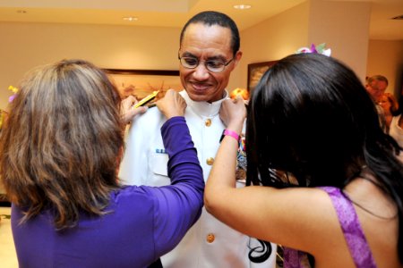 US Navy 120120-N-IT566-020 Adm. Cecil Haney has his new shoulder boards placed on his uniform by his wife and daughter