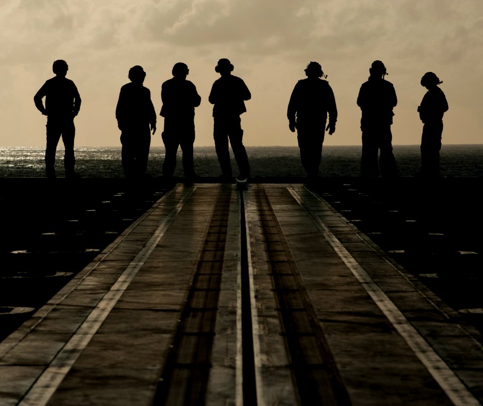 US Navy 111221-N-DR144-116 Sailors muster on the bow for a foreign object damage walk-down on the flight deck aboard the Nimitz-class aircraft carr