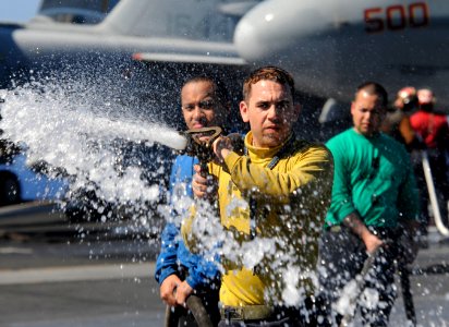 US Navy 111223-N-RG587-286 Aviation Boatswain's Mate (Handling) 3rd Class Sean Pennala hoses down the flight deck of the Nimitz-class aircraft carr