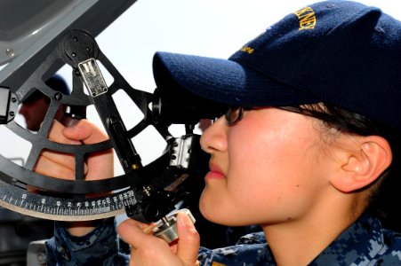 US Navy 111224-N-ED900-015 Ensign Jiatian Yue, assigned to the guided-missile destroyer USS Pinckney (DDG 91), uses a statometer to measure range a