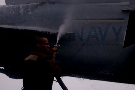 US Navy 111226-N-TZ605-041 A Sailor rinses a jet on the flight deck