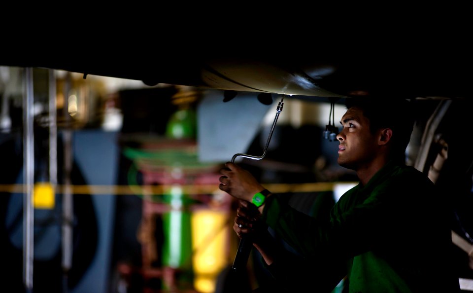 US Navy 120116-N-GC412-395 Aviation Machinist's Mate Airman Panu Beckley tightens a panel screw on an EA-6B Prowler