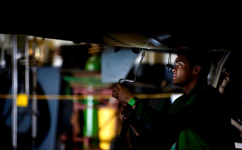 US Navy 120116-N-GC412-395 Aviation Machinist's Mate Airman Panu Beckley tightens a panel screw on an EA-6B Prowler