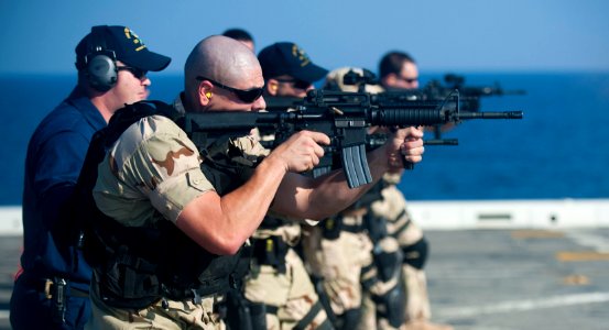 US Navy 111231-N-PB383-564 Ensign Christopher Feldmann, assigned to the visit, board, search, and seizure team, fires his M16 service rifle at a ta