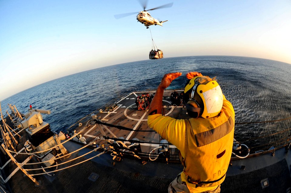 US Navy 111224-N-ED900-105 Boatswain's Mate 3rd Class Victor Hernandez, assigned to the guided-missile destroyer USS Pinckney (DDG 91), directs an