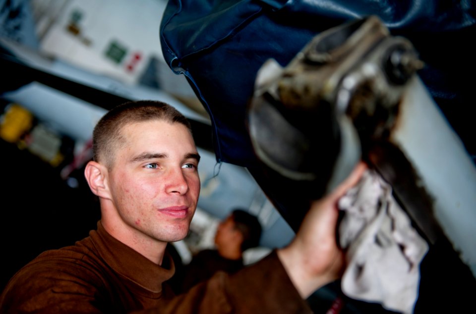 US Navy 111222-N-OY799-138 Aviation Structural Mechanic Airman Joshua Green wipes down the tail hook of an F-A-18C Hornet from the Warhawks of Stri