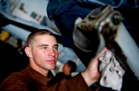 US Navy 111222-N-OY799-138 Aviation Structural Mechanic Airman Joshua Green wipes down the tail hook of an F-A-18C Hornet from the Warhawks of Stri