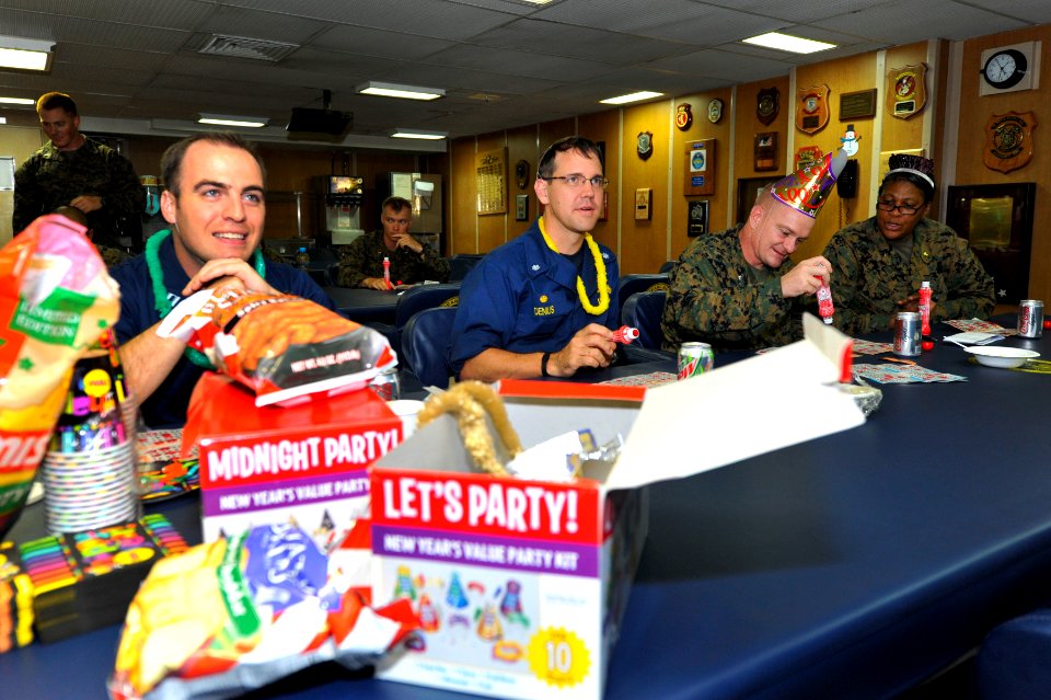US Navy 111231-N-KS651-383 Cmdr. Homer Denius, Lt. Col. Andrew Bergen, and members of the wardroom celebrate New Year's Eve by playing bingo in the