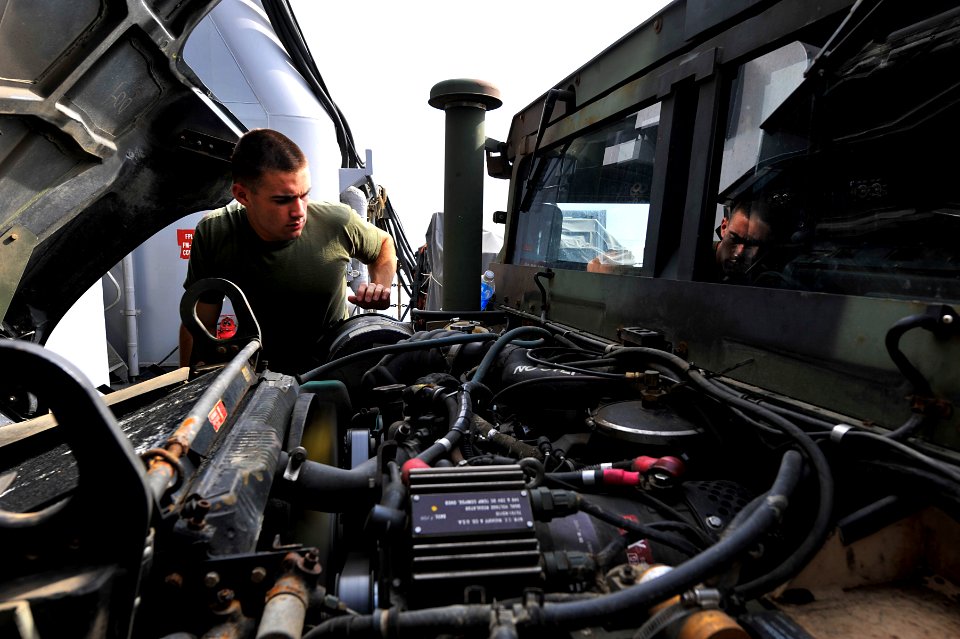 US Navy 111228-N-KS651-092 A Sailor performs maintenance on a Humvee
