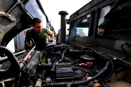 US Navy 111228-N-KS651-092 A Sailor performs maintenance on a Humvee