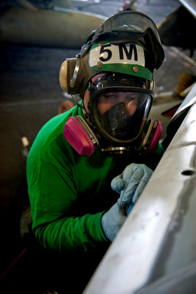 US Navy 111222-N-OY799-034 Aviation Structural Mechanic 2nd Class Robert Isaacs sands corrosion on an EA-6B Prowler from the Wizards of Electronic