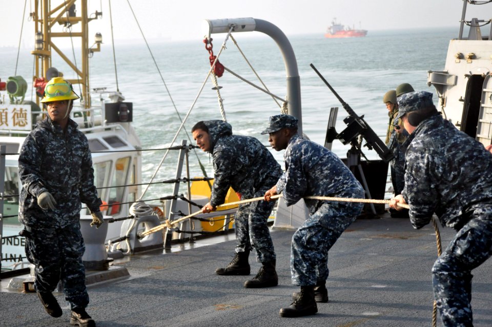 US Navy 111227-N-ZZ999-001 Sailors heave a line aboard USS Chafee