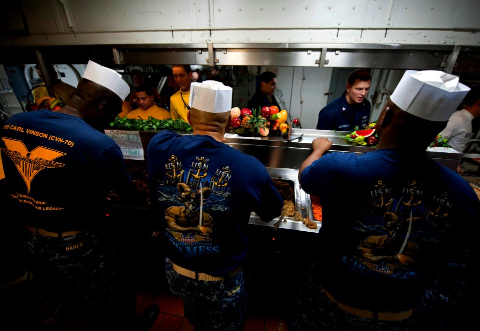 US Navy 111225-N-DR144-178 Chief petty officers serve Christmas dinner on the mess decks aboard the Nimitz-class aircraft carrier USS Carl Vinson (