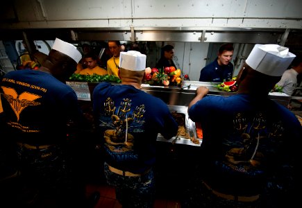 US Navy 111225-N-DR144-178 Chief petty officers serve Christmas dinner on the mess decks aboard the Nimitz-class aircraft carrier USS Carl Vinson (