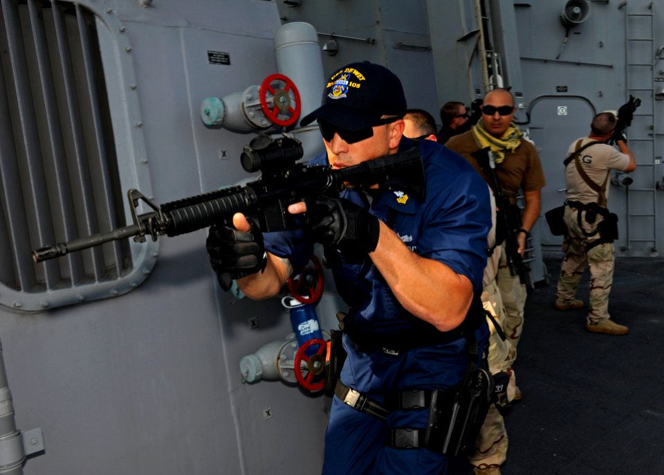 US Navy 111228-N-VH839-016 Electronics Technician 1st Class James Kyne leads a team of Sailors and U.S. Coast Guardsmen around the weather decks du