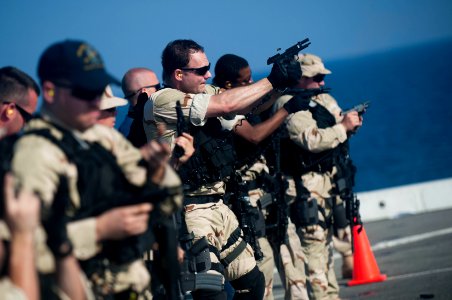 US Navy 111231-N-PB383-595 Hull Technician 1st Class James Reams, assigned to the visit, board, search, and seizure team, fires a 9mm pistol at a t photo
