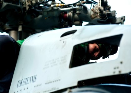US Navy 111229-N-BT887-540 Aviation Structural Mechanic 3rd Class Philip Alexander performs maintenance on an MH-60R Sea Hawk helicopter from the R