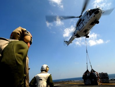 US Navy 111223-N-KA046-222 Marines wait to retrieve a pallet on the flight deck aboard the amphibious assault ship USS Bataan (LHD 5) during a vert