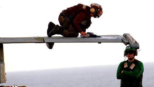 US Navy 111229-N-OY799-115 A Sailor wipes down the wing of an F-A-18C Hornet from the Golden Dragons of Strike Fighter Squadron (VFA) 192 on the fl