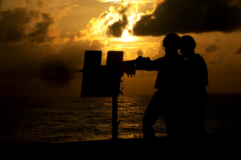 US Navy 111229-N-PB383-202 A Sailor fires a .50-caliber machine gun during a live-fire exercise aboard the amphibious transport dock ship USS New O