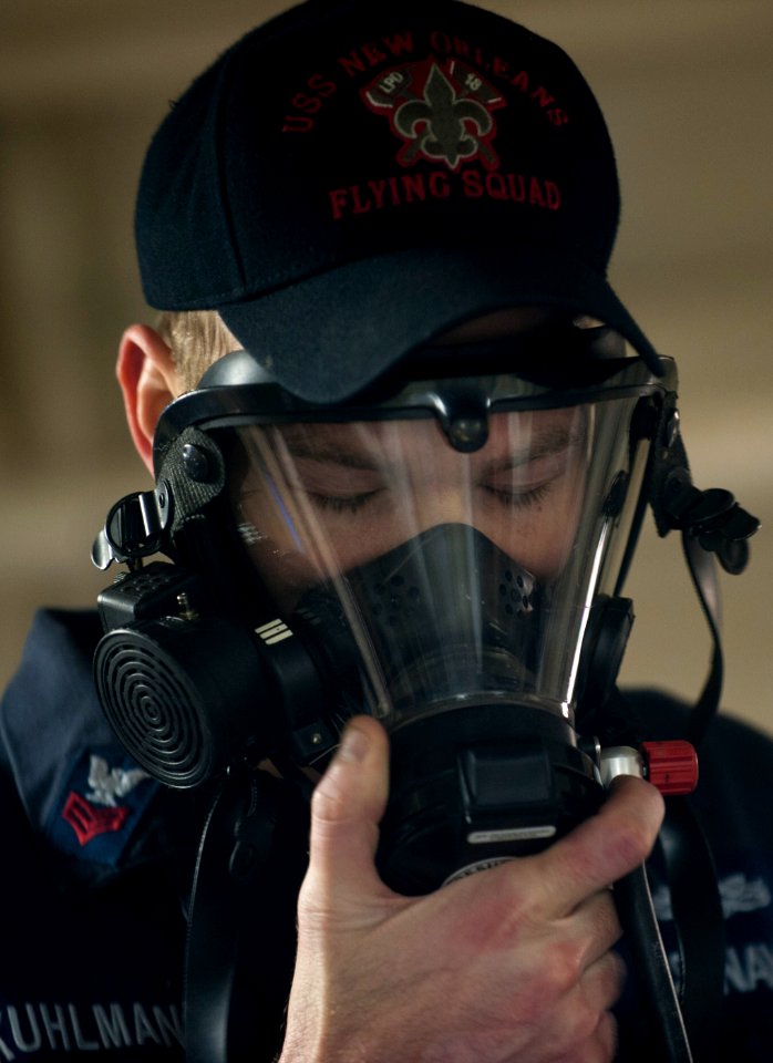 US Navy 120124-N-PB383-163 Damage Controlman 1st Class Justin Kuhlman demonstrates how to properly don a breathing apparatus