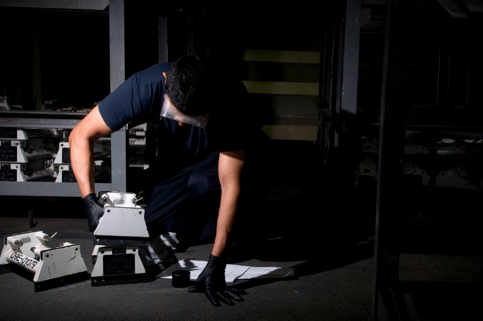US Navy 111226-N-TZ605-087 A Sailor performs maintenance on adapters used for ordnance transport