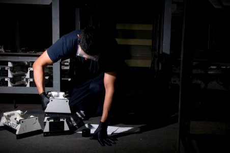 US Navy 111226-N-TZ605-087 A Sailor performs maintenance on adapters used for ordnance transport