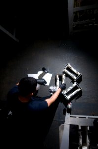 US Navy 111226-N-TZ605-081 A Sailor performs maintenance on adapters used for ordnance transport