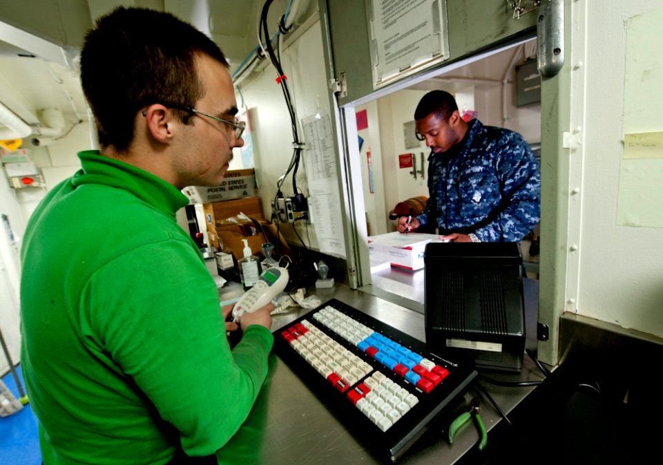 US Navy 111227-N-OY799-209 Logistics Specialist 3rd Class Joel Dunbar, from Boulder City, Nev., assists Aviation Ordnanceman Airman Eric Terrell, f