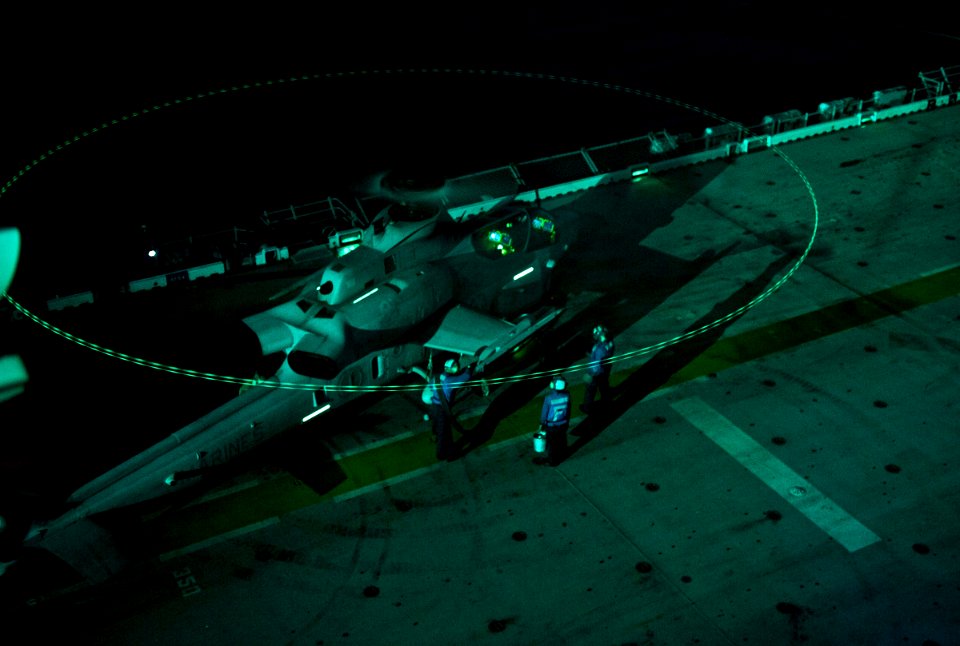 US Navy 111230-N-DX615-140 Sailors conduct a hot refueling of an AH-1W Cobra attack helicopter during night flight operations aboard the amphibious