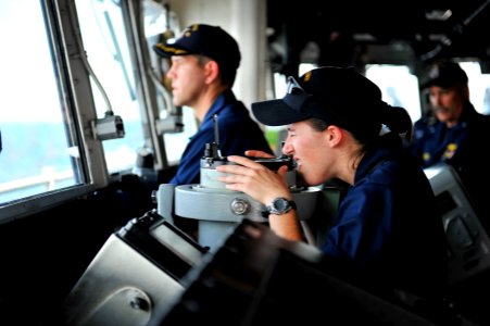 US Navy 111228-N-KS651-127 A Sailor looks through a telescopic alidade in the pilothouse