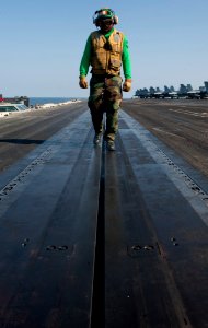 US Navy 120103-N-OY799-062 Aviation Boatswain's Mate (Equipment) 2nd Class Ashawn Robertson walks catapult four checking for any foreign object dam