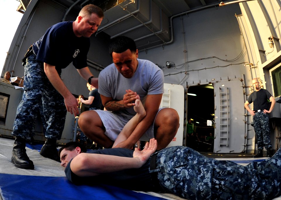 US Navy 111229-N-YB753-101 Machinist's Mate Fireman Apprentice Peni Lemusu demonstrates a control hold on Information Systems Technician 3rd Class
