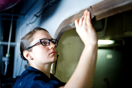 US Navy 120101-N-RJ456-012 Seaman Shelby Eby, from Lewisburg, Ohio, performs corrosion prevention on a hatch aboard the Nimitz-class aircraft carri