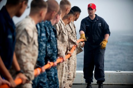 US Navy 120105-N-PB383-003 A Sailor demonstrates how to properly handle a hose during a damage control training exercise