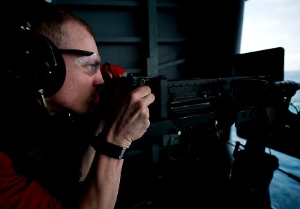 US Navy 120103-N-DR144-188 Aviation Ordnanceman 3rd Class Christopher Crone fires a .50-caliber machine gun during a crew-served weapons fire exerc