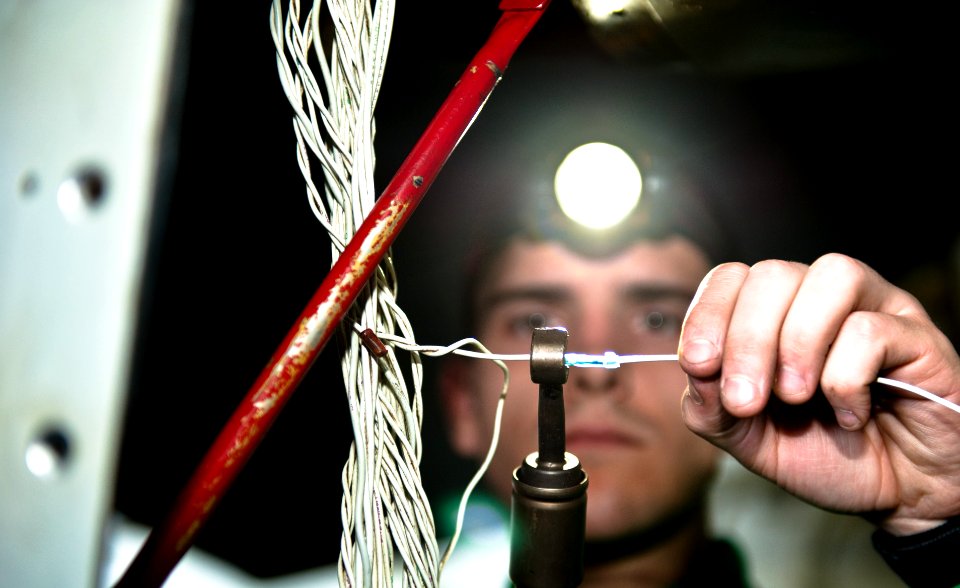 US Navy 120101-N-GC412-009 Aviation Electronics Technician 3rd Class Andrew Godwin rewires a power supply on an EA-6B Prowler from the Wizards of E