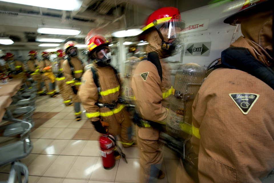 US Navy 120106-N-DR144-080 Members of the ship's flying squad line up on the mess decks as they prepare to enter a space and combat a simulated fir