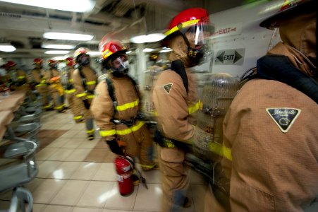 US Navy 120106-N-DR144-080 Members of the ship's flying squad line up on the mess decks as they prepare to enter a space and combat a simulated fir