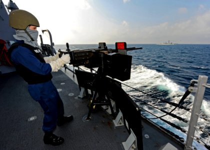 US Navy 120105-N-VH839-025 Fire Controlman 2nd Class Milo Wilson mans a double-mounted .50-caliber machine gun