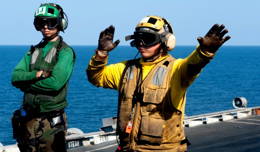 US Navy 120103-N-OY799-086 Aviation Boatswain's Mate (Handling) 3rd Class Daniel War directs an aircraft onto catapult four on the flight deck of t