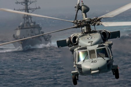US Navy 120102-N-DR144-050 An MH-60S Knight Hawk assigned to Helicopter Sea Combat Squadron (HSC) 23 passes the Arleigh Burke-class guided-missile