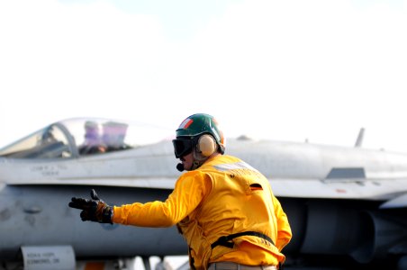 US Navy 111231-N-GZ832-182 Lt. Blake Whetstone, assigned to the air department aboard the aircraft carrier USS Carl Vinson (CVN 70), signals for th