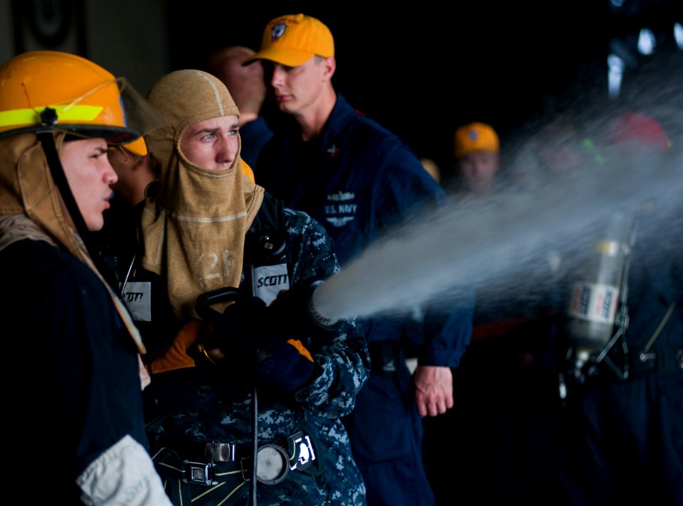 US Navy 120104-N-DX615-092 Boatswain's Mate 3rd Class Trevor Mink practices proper hose handling techniques during a general quarters drill aboard