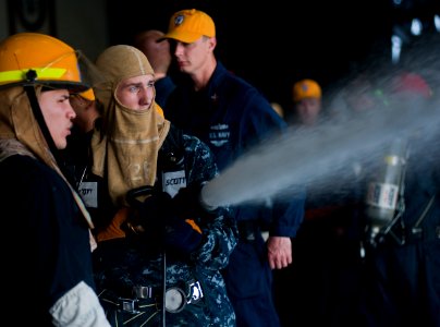 US Navy 120104-N-DX615-092 Boatswain's Mate 3rd Class Trevor Mink practices proper hose handling techniques during a general quarters drill aboard