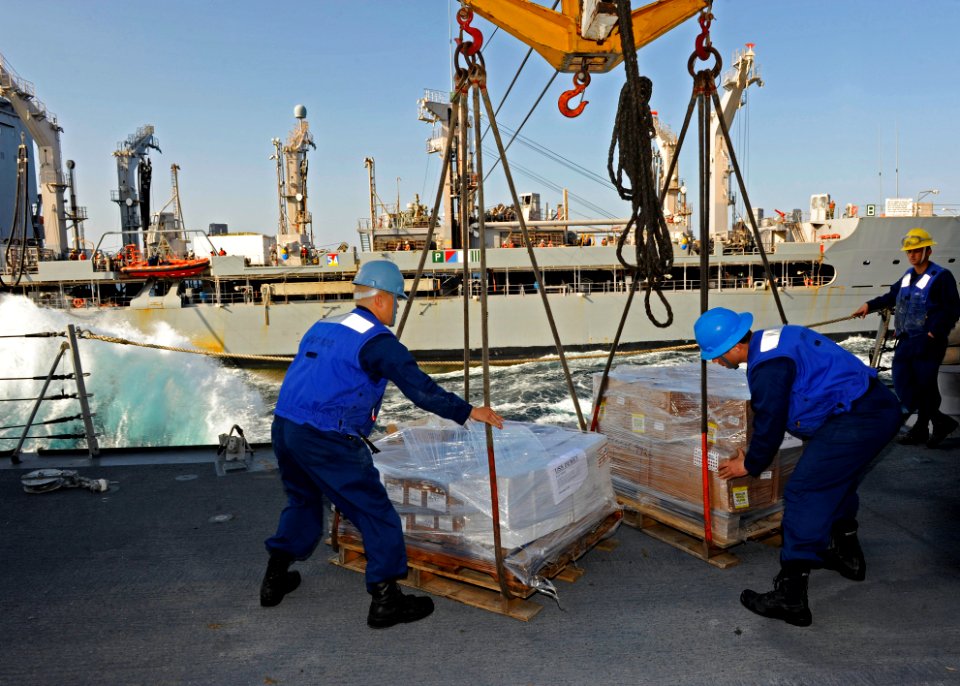 US Navy 111231-N-VH839-016 Ship's Serviceman 3rd Class Bennettebryan Apostol, left, and Seaman Eric Roehrig detach incoming pallets from a rig aboa