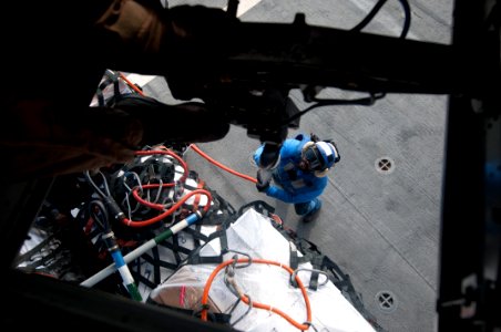US Navy 120104-N-PB383-209 A civilian mariner connects cargo to a helicopter