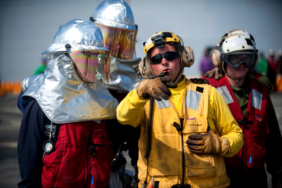 US Navy 120103-N-PB383-382 Aviation Boatswain's Mate (Handling) 2nd Class Mark Thornton instructs damage controlmen during a flight deck firefighti